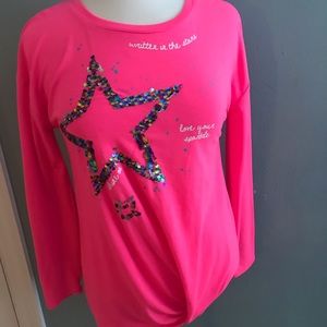 A pink shirt with a sequenced star.